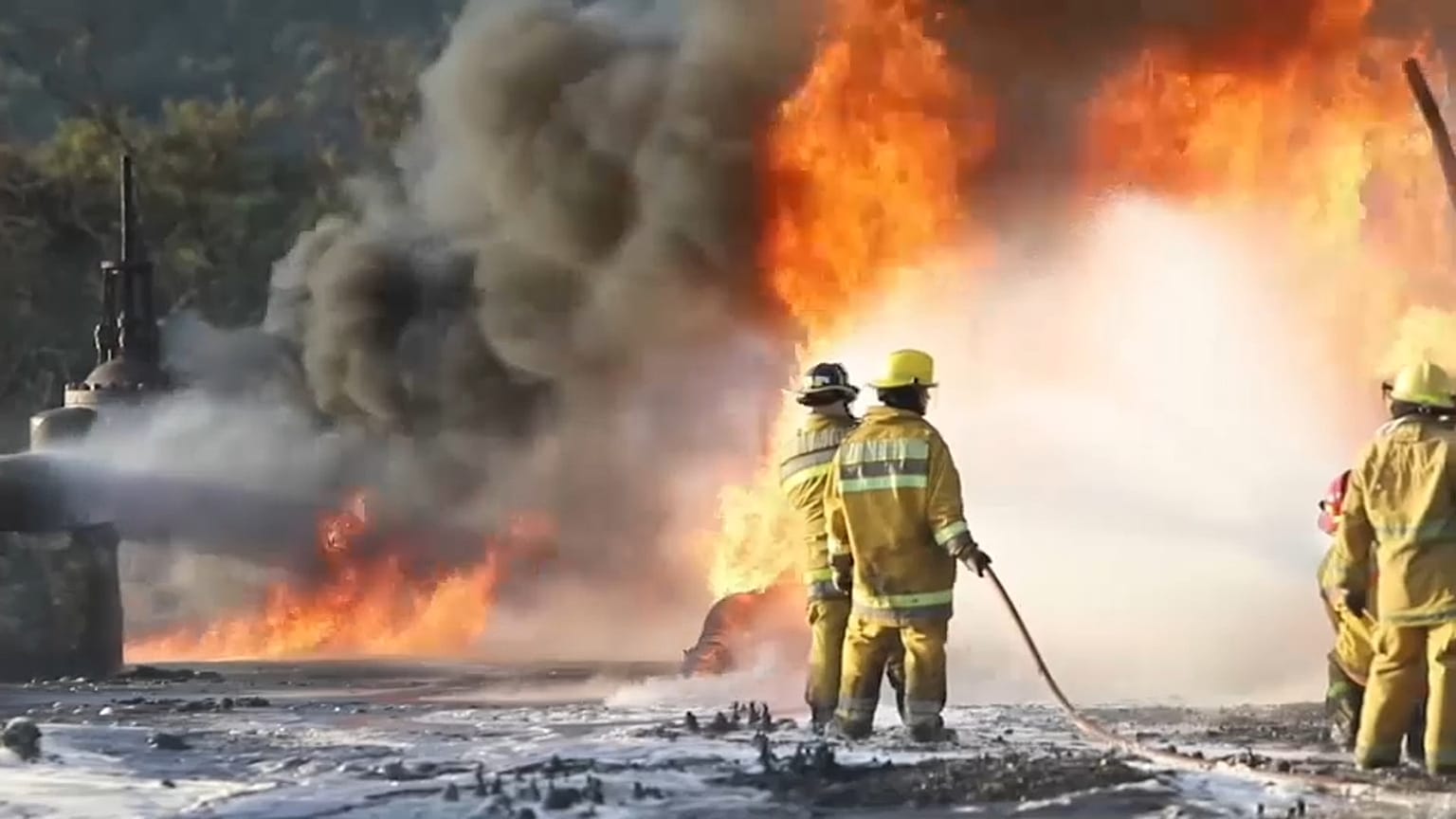 Los bomberos trabajando para contener las llamas tras la explosión en un ducto de gasolina en Venezuela.