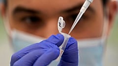 Research assistant Robert demonstrates how to prepare a sample for sequencing at the Wellcome Sanger Institute, Genome Campus, Hinxton, Cambridgeshire, England