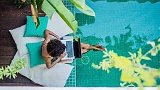 A woman works by a swimming pool 