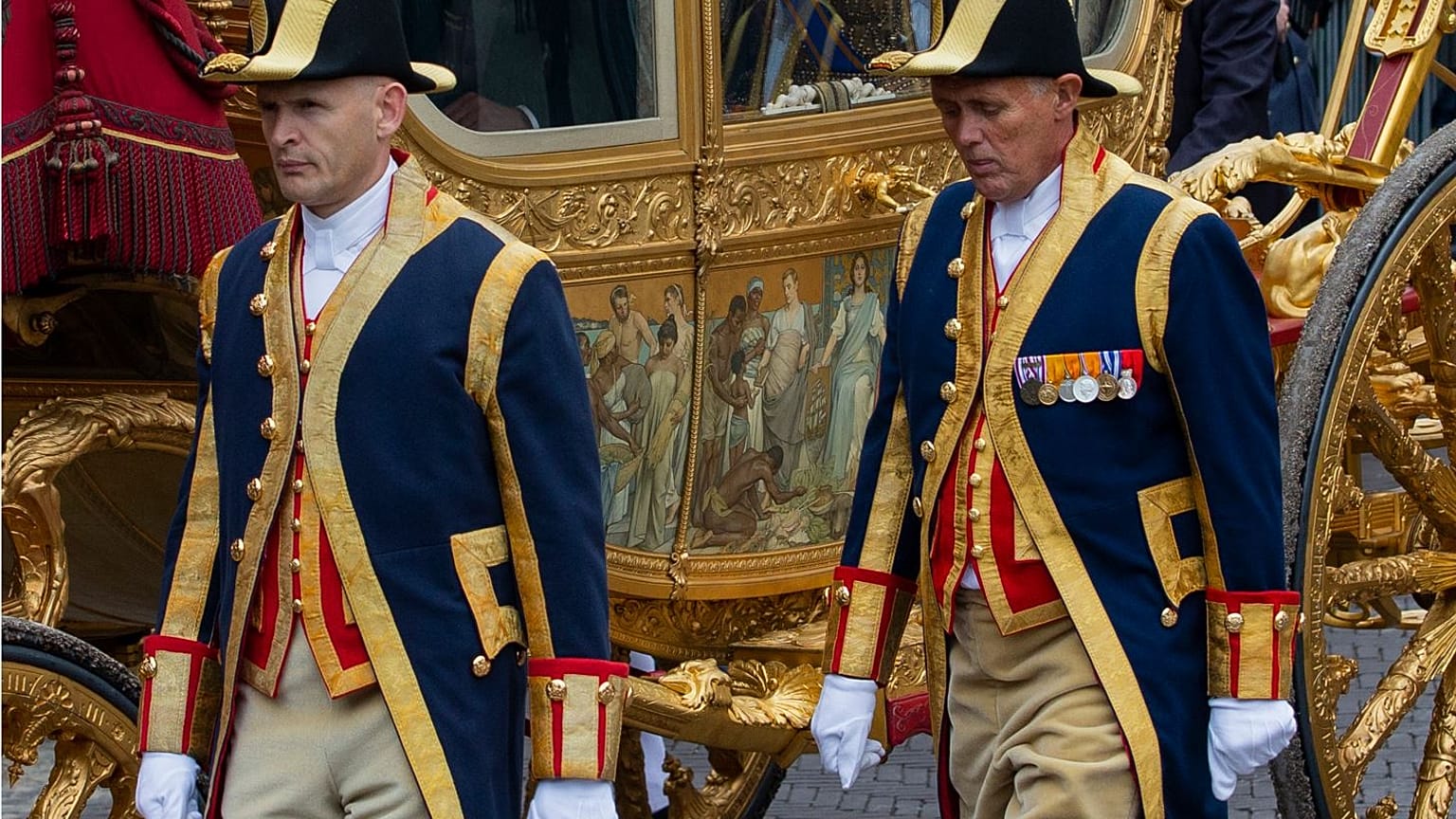 Footmen walk alongside the Golden Carriage as Netherlands' King Willem-Alexander and Queen Maxima arrive at Noordeinde Palace in 2013.