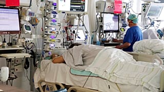 A nurse checks a monitor as he stands by a patient in the COVID intensive care unit at the SRH Wald-Klinikum in Gera, Germany, Thursday, Jan. 13, 2022.