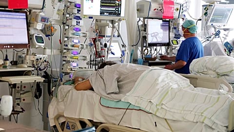 A nurse checks a monitor as he stands by a patient in the COVID intensive care unit at the SRH Wald-Klinikum in Gera, Germany, Thursday, Jan. 13, 2022.