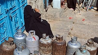 امرأة تنتظر لملء أسطوانة الغاز وسط نقص شديد في مدينة تعز اليمنية