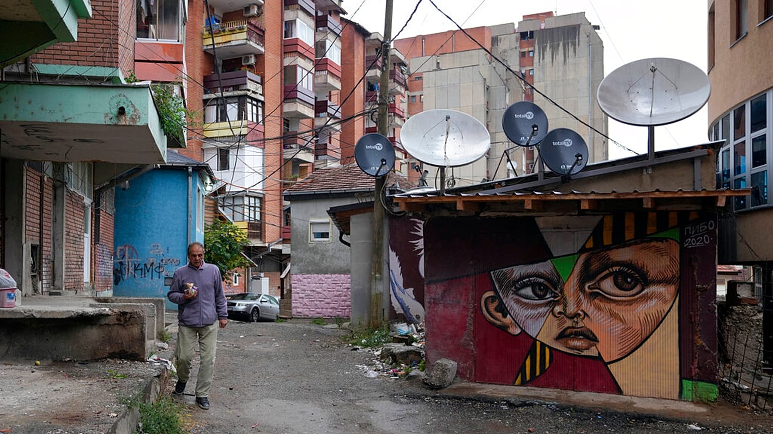 A man walks through northern, Serb-dominated part of ethnically divided town of Mitrovica, Kosovo, Friday, Oct. 15, 2021.