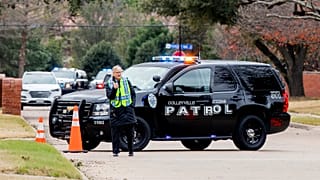 Law enforcement officials block a residential street near Congregation Beth Israel synagogue where a man took hostages during services on Saturday, January 15