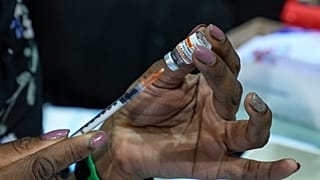 Медсестра набирает в шприц вакцину от коронавируса Pfizer для прививки ребёнка. Ивлин, Франция, 22 декабря 2021