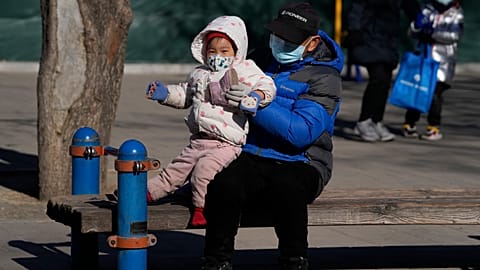 A man lifts a child at a park in Beijing, China, Thursday, Jan. 13, 2022. 