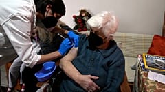 ممرّضة تقدّم جرعة ثانية من لقاح فايزر لمسنّة تجاوزت الـ 90 من عمرها، في منزلها بأثينا، الأربعاء ، 22 ديسمبر، 2021