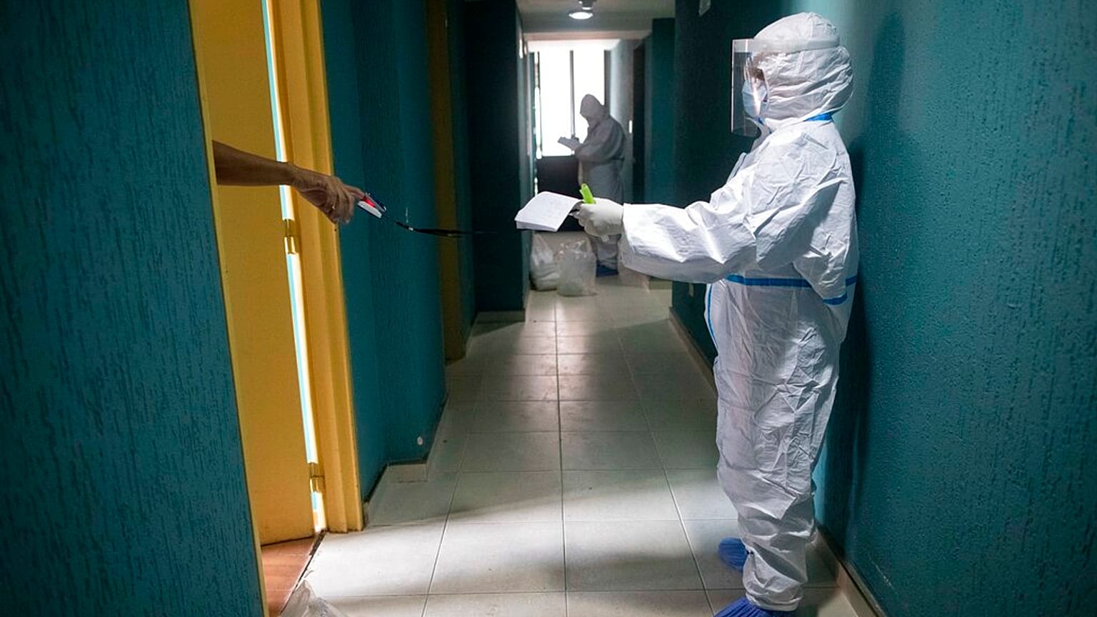 Un médico se sitúa a distancia para hacer pruebas a un paciente asintomático de COVID-19 en Caracas, Venezuela.