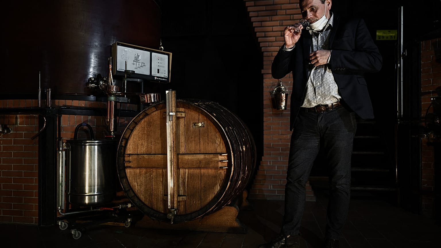 Distillery owner Eric Pinard checks the distillation process of Cognac, a white wine eau-de-vie obtained from a double distillation in a Charentais still 
