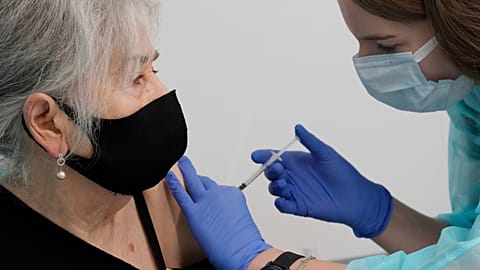 FILE - Hanna Zientara, an 83-year-old resident of Warsaw, receives a booster shot against COVID-19, in Warsaw, Poland, on Dec. 7, 2021.