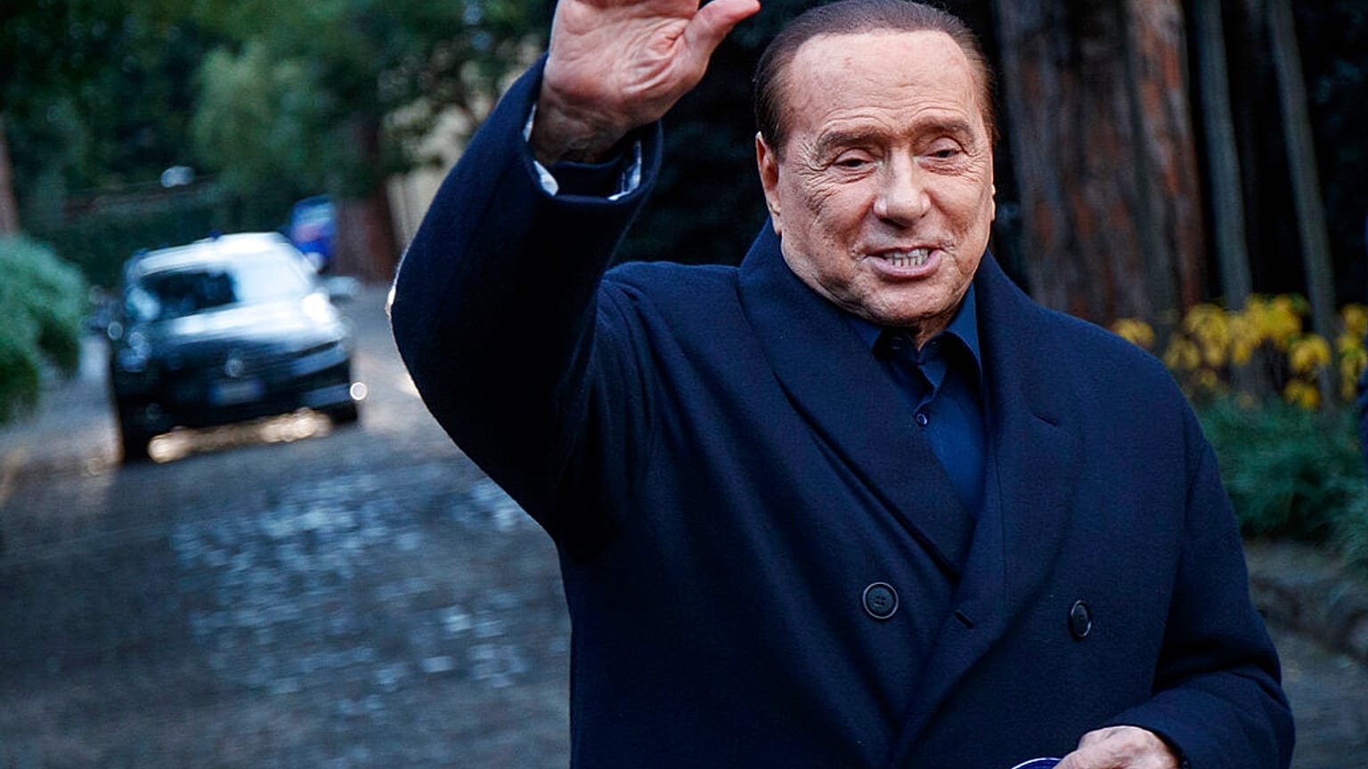 El ex primer ministro italiano Silvio Berlusconi saluda a los medios de comunicación tras una reunión con dirigentes de centro-derecha en Roma en diciembre de 2021