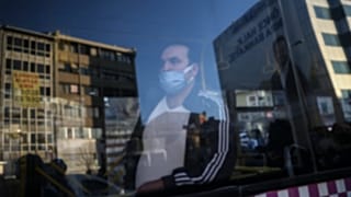 İstanbul'da otobüsten bir protesto gösterisini izleyen yolcu.