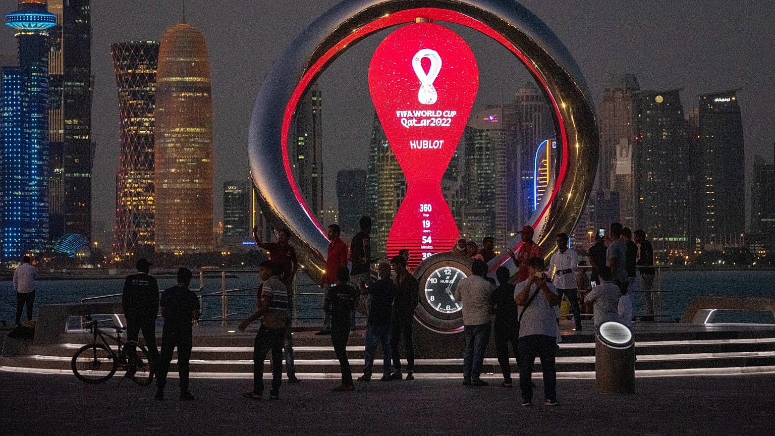 People gather around the official countdown clock showing remaining time until the kick-off of the World Cup 2022, in Doha, Qatar, Nov. 25, 2021.