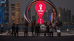 People gather around the official countdown clock showing remaining time until the kick-off of the World Cup 2022, in Doha, Qatar, Nov. 25, 2021.