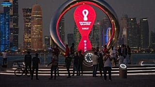 People gather around the official countdown clock showing remaining time until the kick-off of the World Cup 2022, in Doha, Qatar, Nov. 25, 2021.