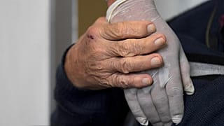 صورة رمزية لعجوز يمسك يد ممرضة في أحد مستشفيات كولومبيا