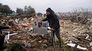  فلسطيني يحمل صوراً عائلية على أنقاض منزل هدمته بلدية القدس، في حي الشيخ جراح بالقدس الشرقية، 19 يناير، 2022