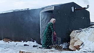 Une femme devant son abri de fortune dans un camp pour réfugiés d'Afrin (Syrie), le 19 janvier 2022
