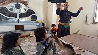 رجل يظهر شظية من غارة جوية بقيادة السعودية على موقع عسكري قريب اخترقت جدار شقته في صنعاء  