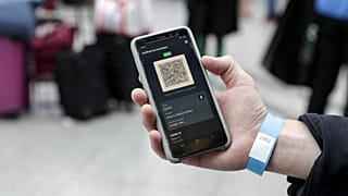 A passenger shows his Covid-19 health pass on a mobile phone at a French train station.