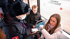 A controller checks a QR code and observance of the mask regime in public transport in Moscow
