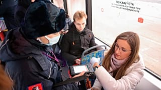 A controller checks a QR code and observance of the mask regime in public transport in Moscow