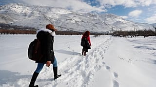 شخصان يسيران على الثلج بريف دمشق، سوريا، الجمعة 21 كانون الثاني 2022.