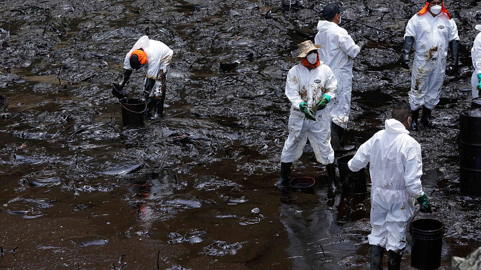 Un grupo de trabajadores realiza tareas de limpieza de petróleo en la playa de Cavero, en el distrito de Callao