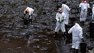 Un grupo de trabajadores realiza tareas de limpieza de petróleo en la playa de Cavero, en el distrito de Callao