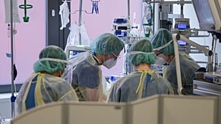 طاقم طبي في مستشفى سانا كلينيكوم أوفنباخ في ألمانيا يعتنون بمريض في وحدة العناية المركزة لمرضى كورونا 