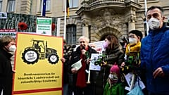 Der deutsche Landwirtschaftsminister Cem Özdemir hält einen Miniaturtraktor nach Protesten vor dem Landwirtschaftsministerium in Berlin