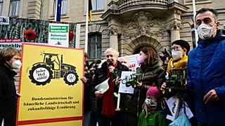 Der deutsche Landwirtschaftsminister Cem Özdemir hält einen Miniaturtraktor nach Protesten vor dem Landwirtschaftsministerium in Berlin