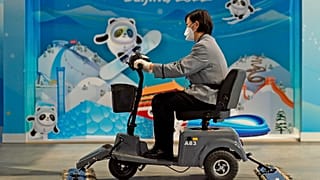 Eine Putzkraft reinigt den Boden im Medienzentrum der Olympischen Winterspiele in Peking.