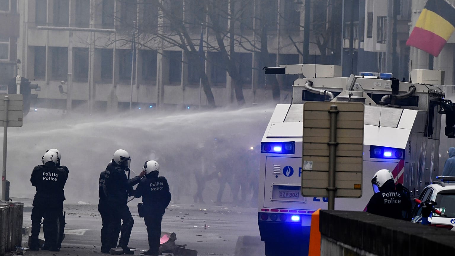 Police set off a water cannon against protestors during a demonstration against COVID-19 measures in Brussels, Sunday, Jan. 23, 2022