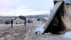 Displaced Syrian children walk in the snow at a refugee camp, in Afrin, north of Aleppo, Syria, on 19 January 2022.