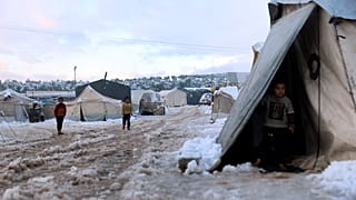 Displaced Syrian children walk in the snow at a refugee camp, in Afrin, north of Aleppo, Syria, on 19 January 2022.
