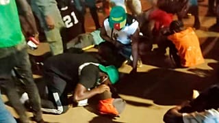 People assist victims of a stampede outside a stadium in Yaounde