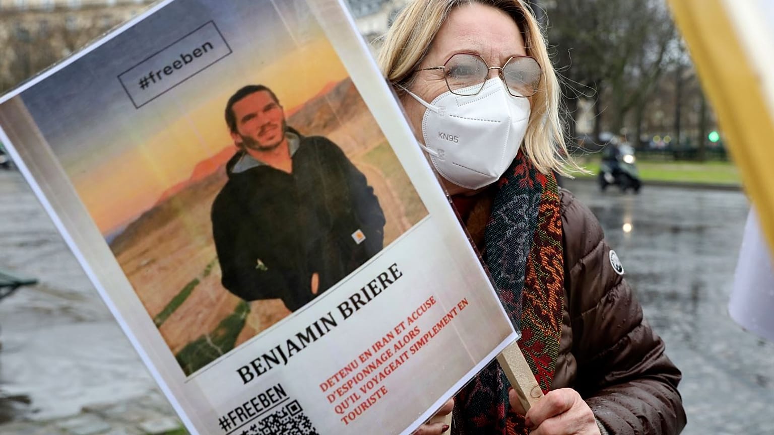 A woman holds a photo of Benjamin Briere during a rally in Paris earlier this month.