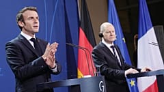 German Chancellor Olaf Scholz (R) and French President Emmanuel Macron address a joint press conference ahead of talks at the Chancellery in Berlin on January 25, 2022. 