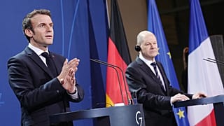 German Chancellor Olaf Scholz (R) and French President Emmanuel Macron address a joint press conference ahead of talks at the Chancellery in Berlin on January 25, 2022. 
