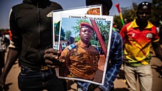 Un sostenitore dei golpisti tiene in mano la foto del tenente colonnello Paul Henri Sandaogo Damiba