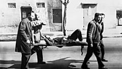 متطوعون يحملون جثة أحد ضحايا إطلاق النار في شارع إيسلي بالجزائر العاصمة في 26 مارس 1962