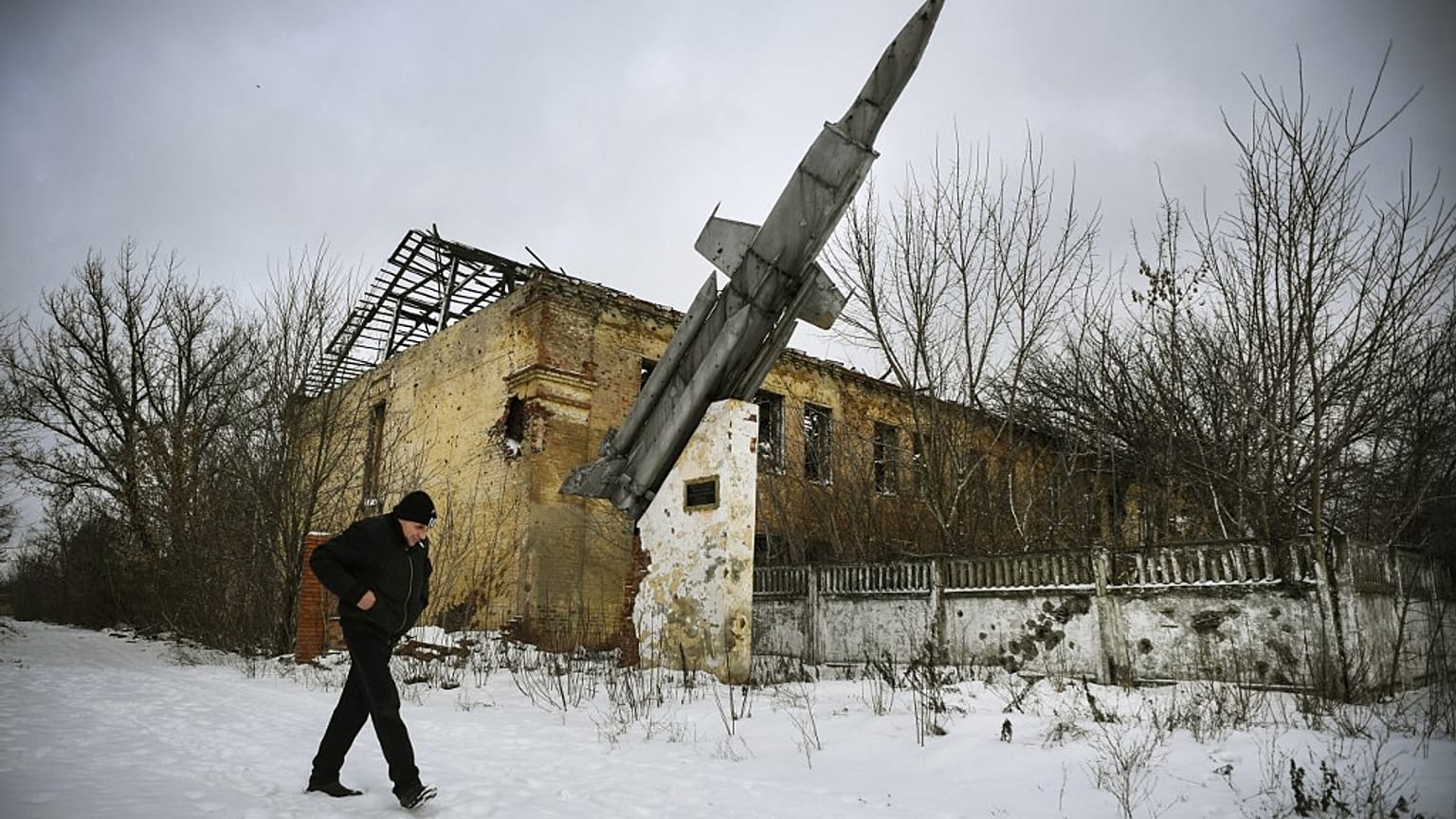 A man walks past a destroyed building of a former military installation in the village of Vesyoloye, suburb of Donetsk, capital of a self-proclaimed Donetsk People's Republic 