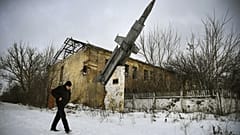 A man walks past a destroyed building of a former military installation in the village of Vesyoloye, suburb of Donetsk, capital of a self-proclaimed Donetsk People's Republic 