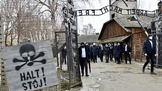 French PM Jean Castex stands at the gate during a visit at the Memorial and Museum Auschwitz-Birkenau of the former German Nazi concentration and extermination camp.