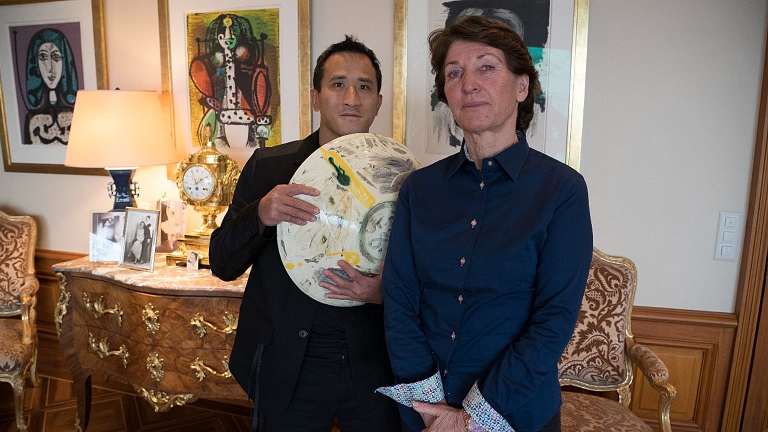 Marina Picasso, right, granddaughter of artist Pablo Picasso, and her son Florian Picasso pose with a ceramic art-work of Pablo Picasso that is NOT going on sale as NFTs 