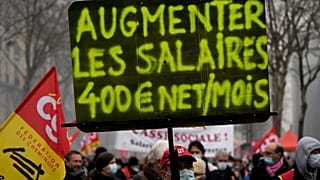 لافتة كتب عليها "زيادة الرواتب 400 يورو شهريا" خلال مظاهرة احتجاجية ضد غلاء المعيشة في باريس. 2022/01/27