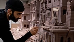 Syrian sculptor Khaled Dawwa works on a clay artpiece, representing a street in Syria destroyed by Syrian regime forces, in his workshop in Vanves, near Paris, January 9, 2022