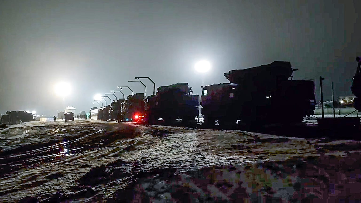 Russian military vehicles prepares to drive off a railway platforms after arrival in Belarus